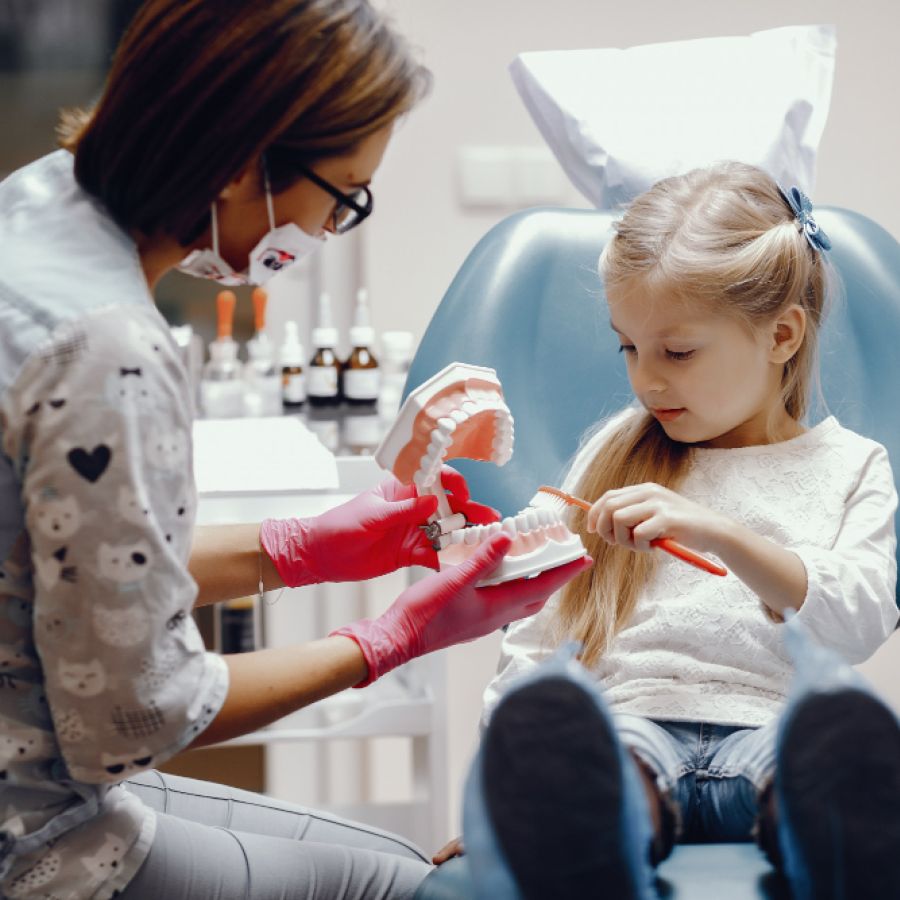 Cute little girl sitting in the dentist's office