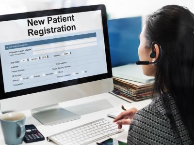 receptionist at a computer registering a new patient