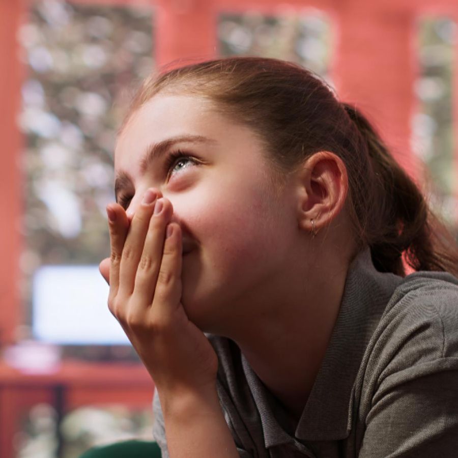Young girl covering her mouth
